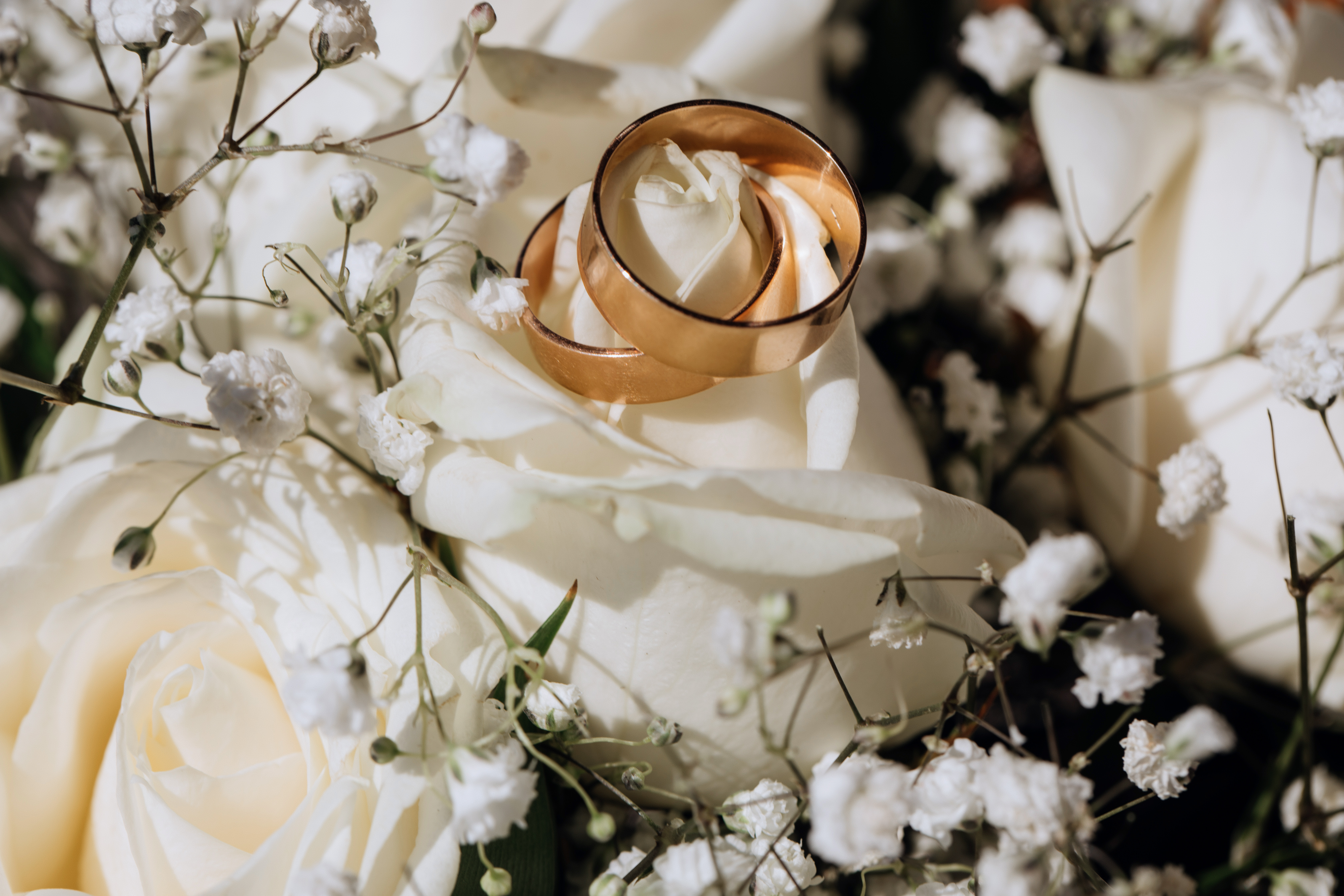 golden-wedding-rings-white-rose-from-wedding-bouquet
